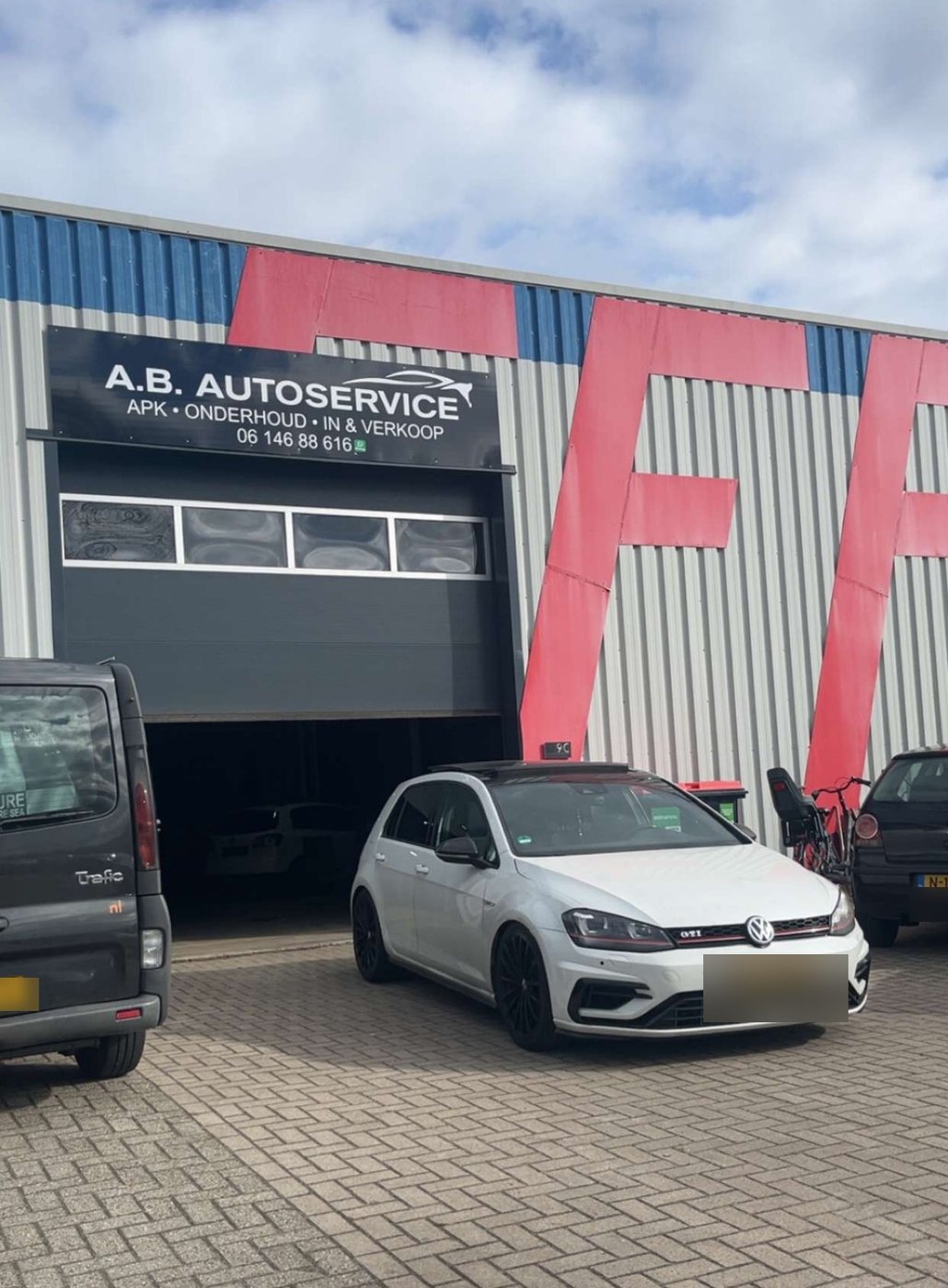 Auto's van klanten voor de roldeur van A.B.Autoservice aan de Kapitein Nemostraat in Emmen